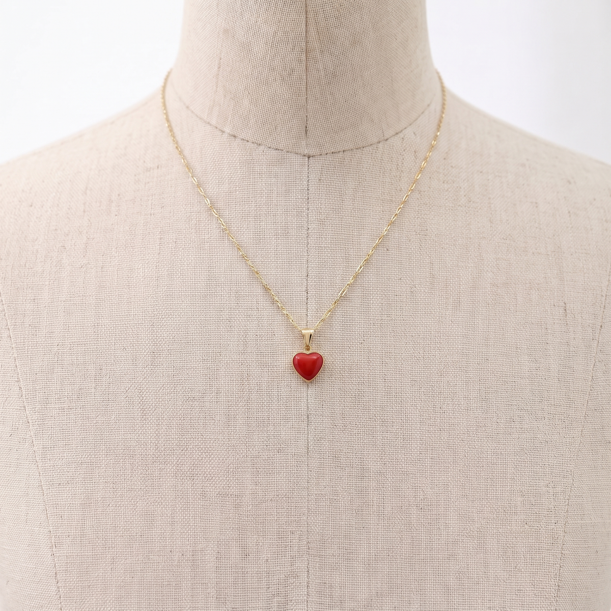 CORALIA — collier pendentif en corail présenté sur un buste en lin