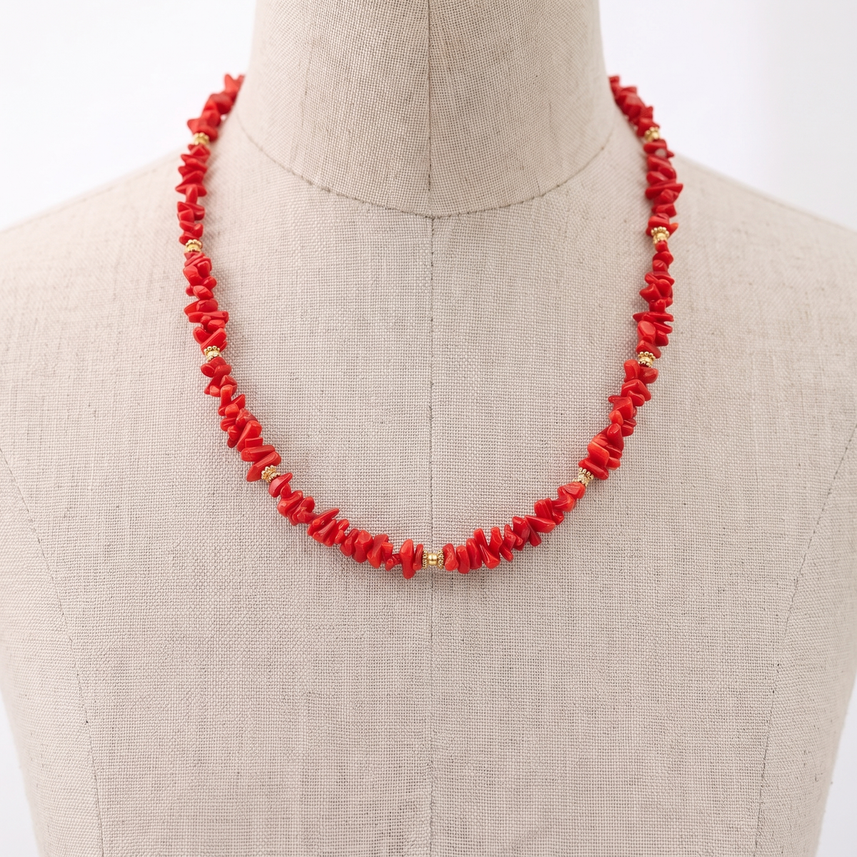 LÜMA — collier en corail présenté sur un buste en lin