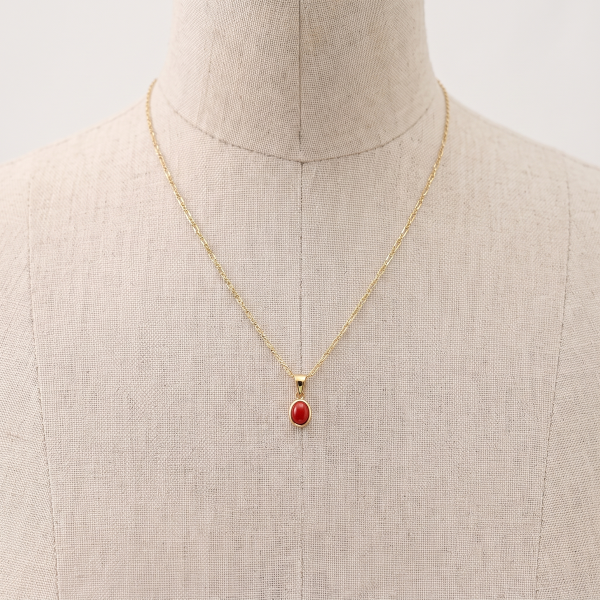 EALARA — collier pendentif en corail présenté sur un buste en lin