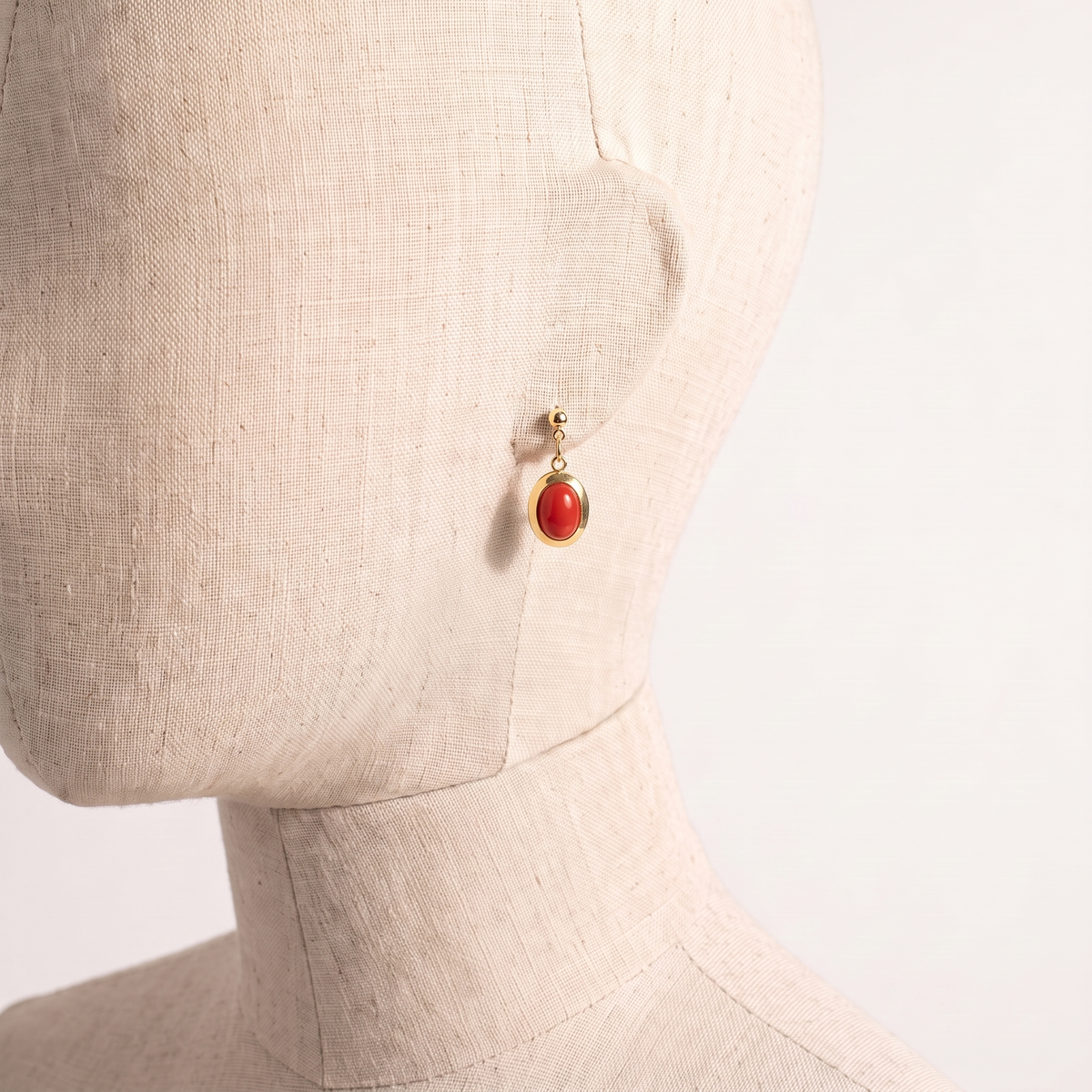 NOEA — boucles d'oreilles en corail présentées sur une oreille en lin