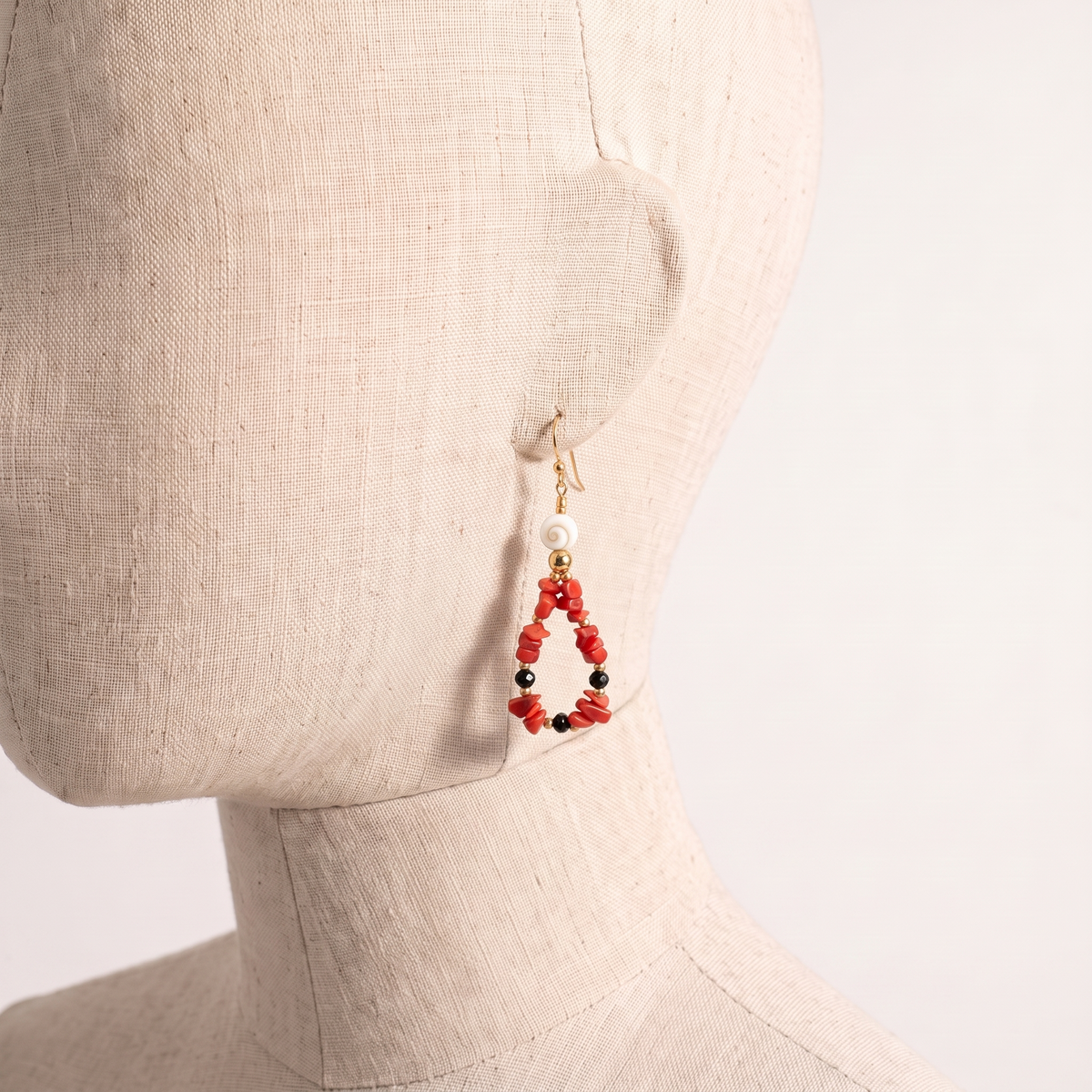 CÉLINA — boucles d'oreilles en corail présentées sur une oreille en lin