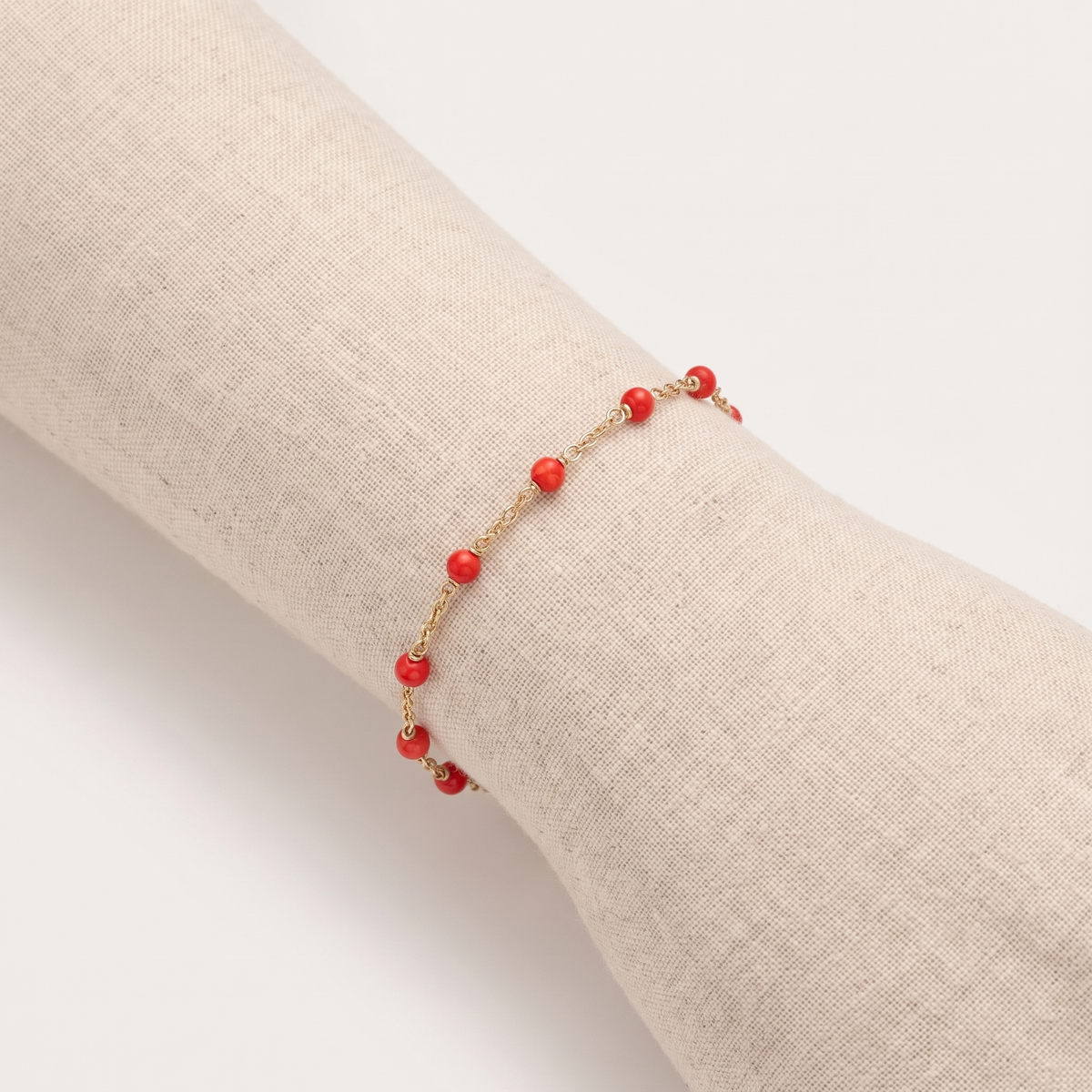 GAÏA — bracelet en corail sur un présentoir poignet en lin