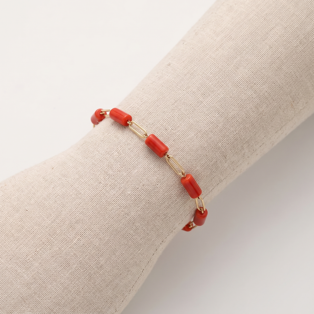 NERINA — bracelet en corail sur un présentoir poignet en lin