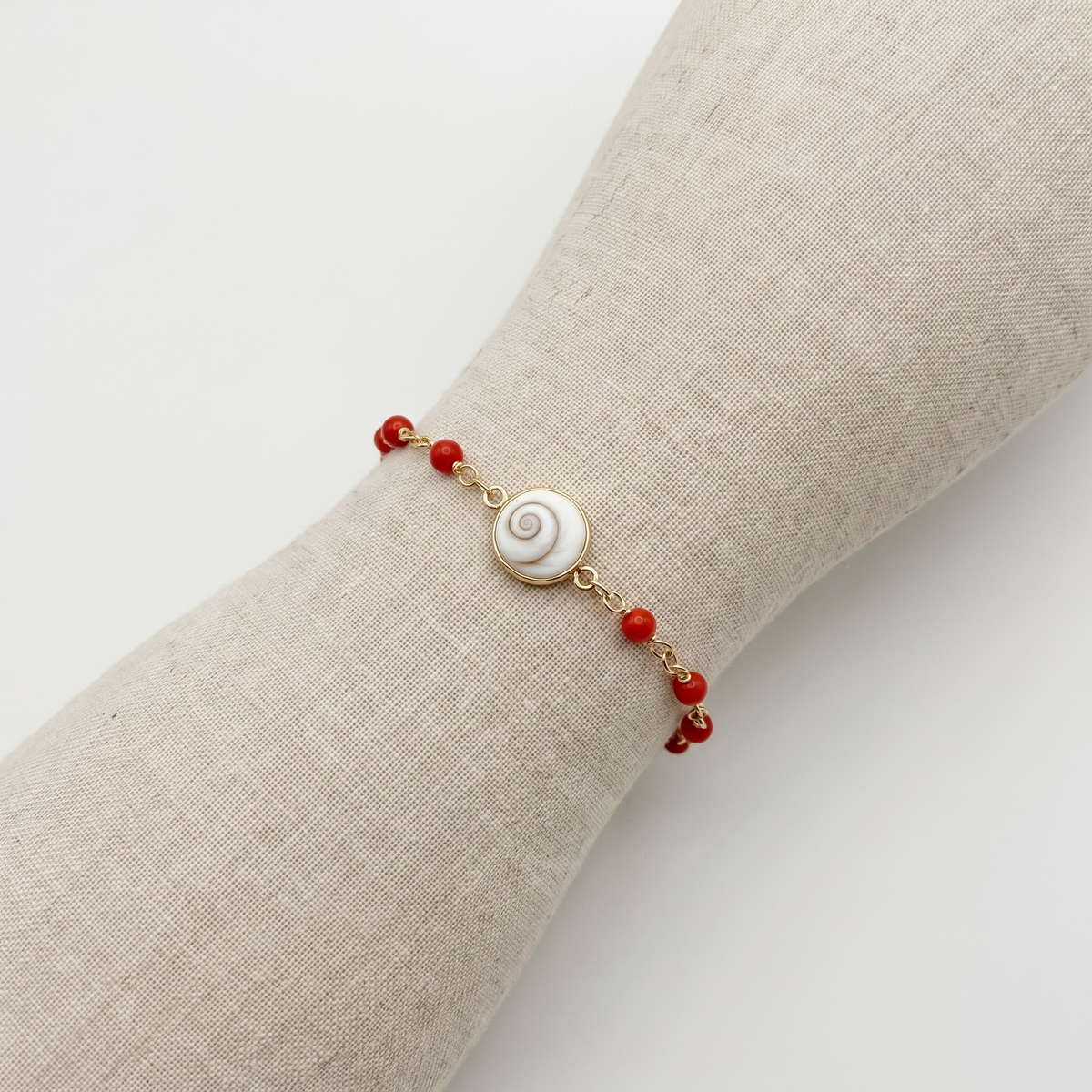 AZURA — bracelet en corail sur un présentoir poignet en lin
