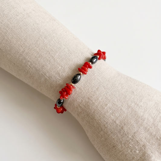 NYX — bracelet en corail sur un présentoir poignet en lin