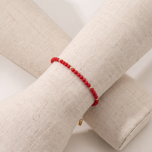 TÉTHYS — bracelet en corail sur un présentoir poignet en lin