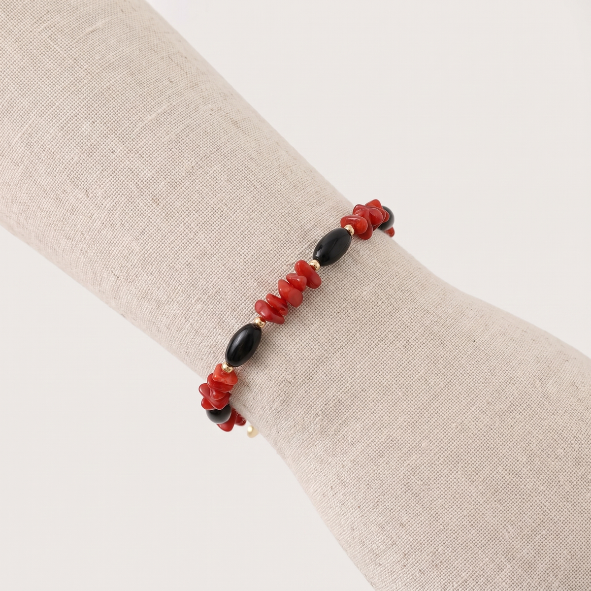 SELENE — bracelet en corail sur un présentoir poignet en lin