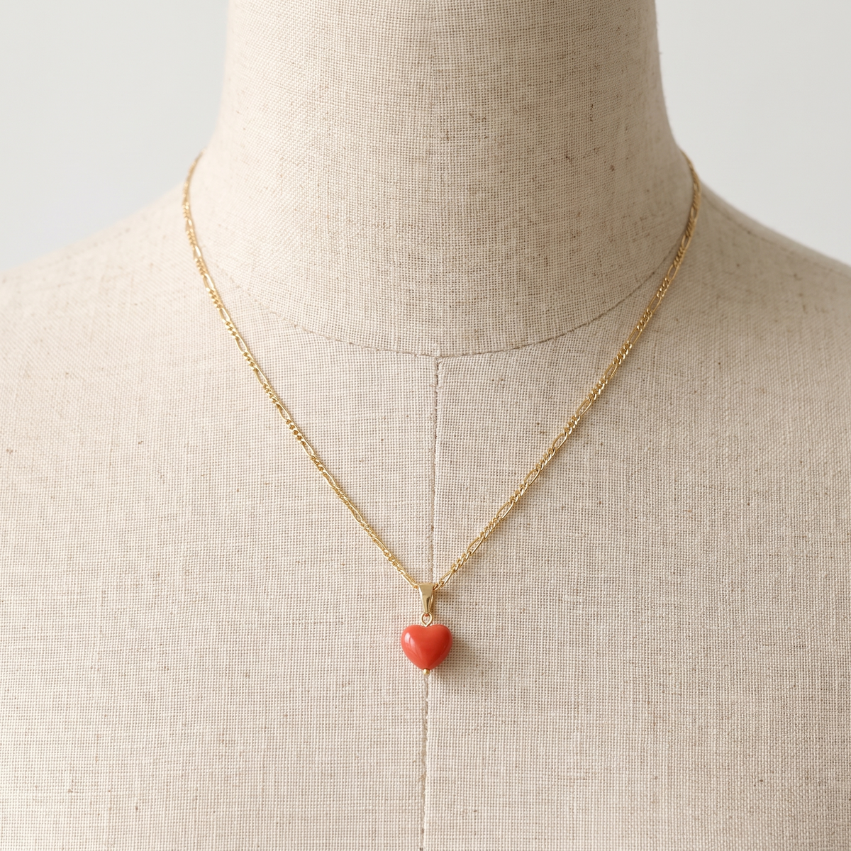 KARDIA — collier pendentif cœur en corail présenté sur un buste en lin